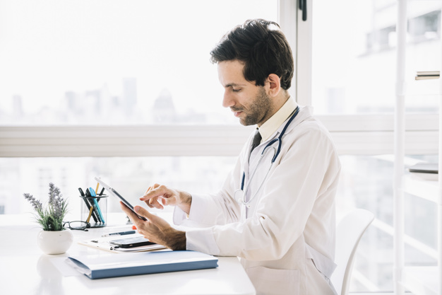 side-view-male-doctor-using-digital-tablet-clinic_23-2147941770